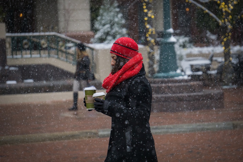 woman walking while holding green cups