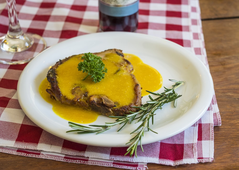 Cooked pork chop on round white ceramic plate