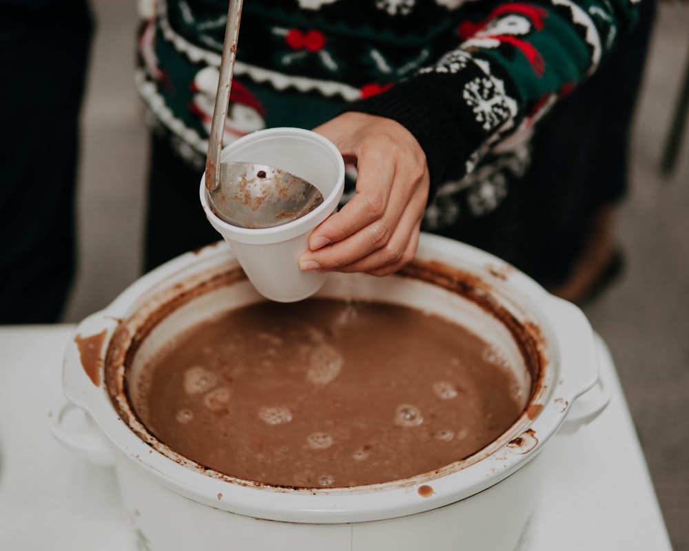 person holding white cup