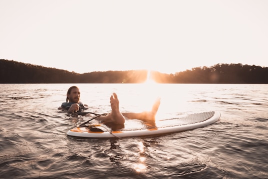 man floating on body of water