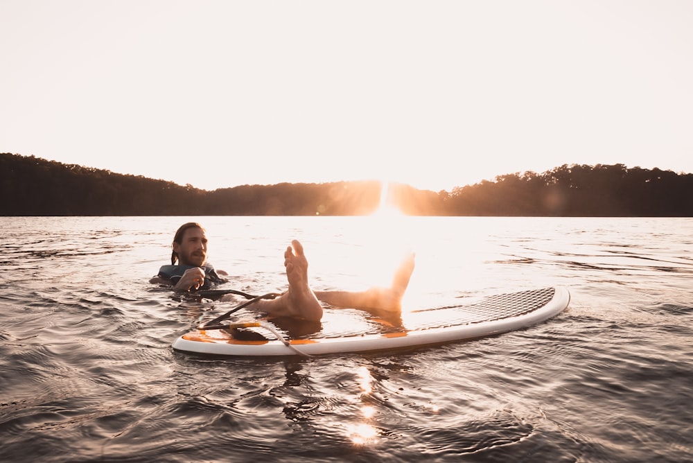 man floating on body of water