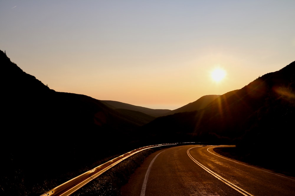 road between mountains during sunset