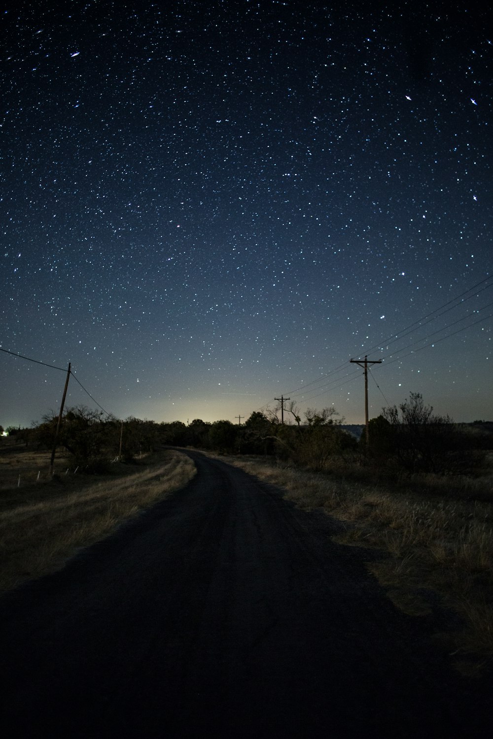 strada vuota sotto notti stellate