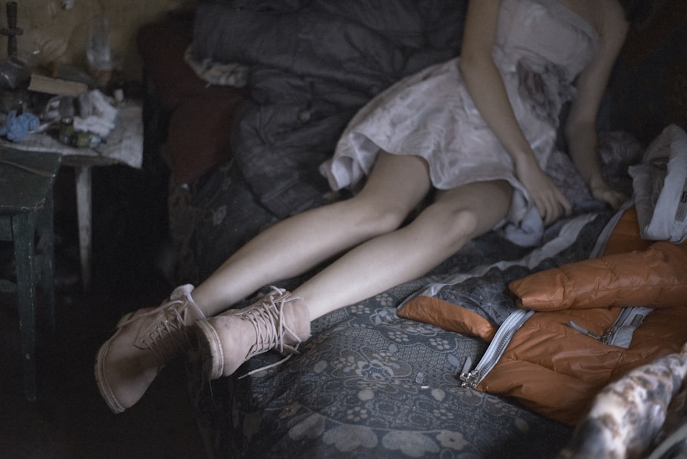 Eine Frau, die mit gekreuzten Beinen auf einem Bett liegt