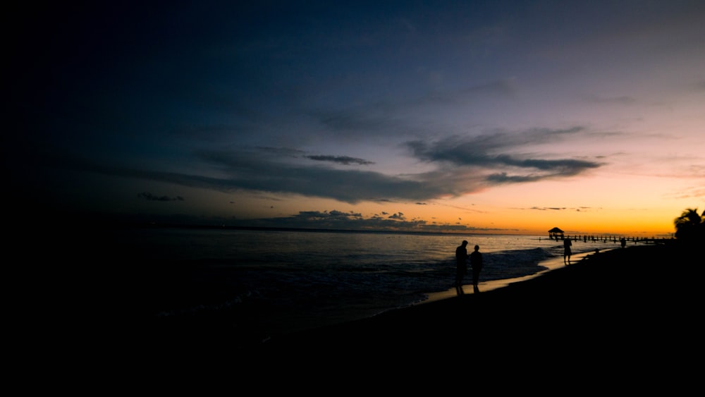 silhouette of person standing near body of water