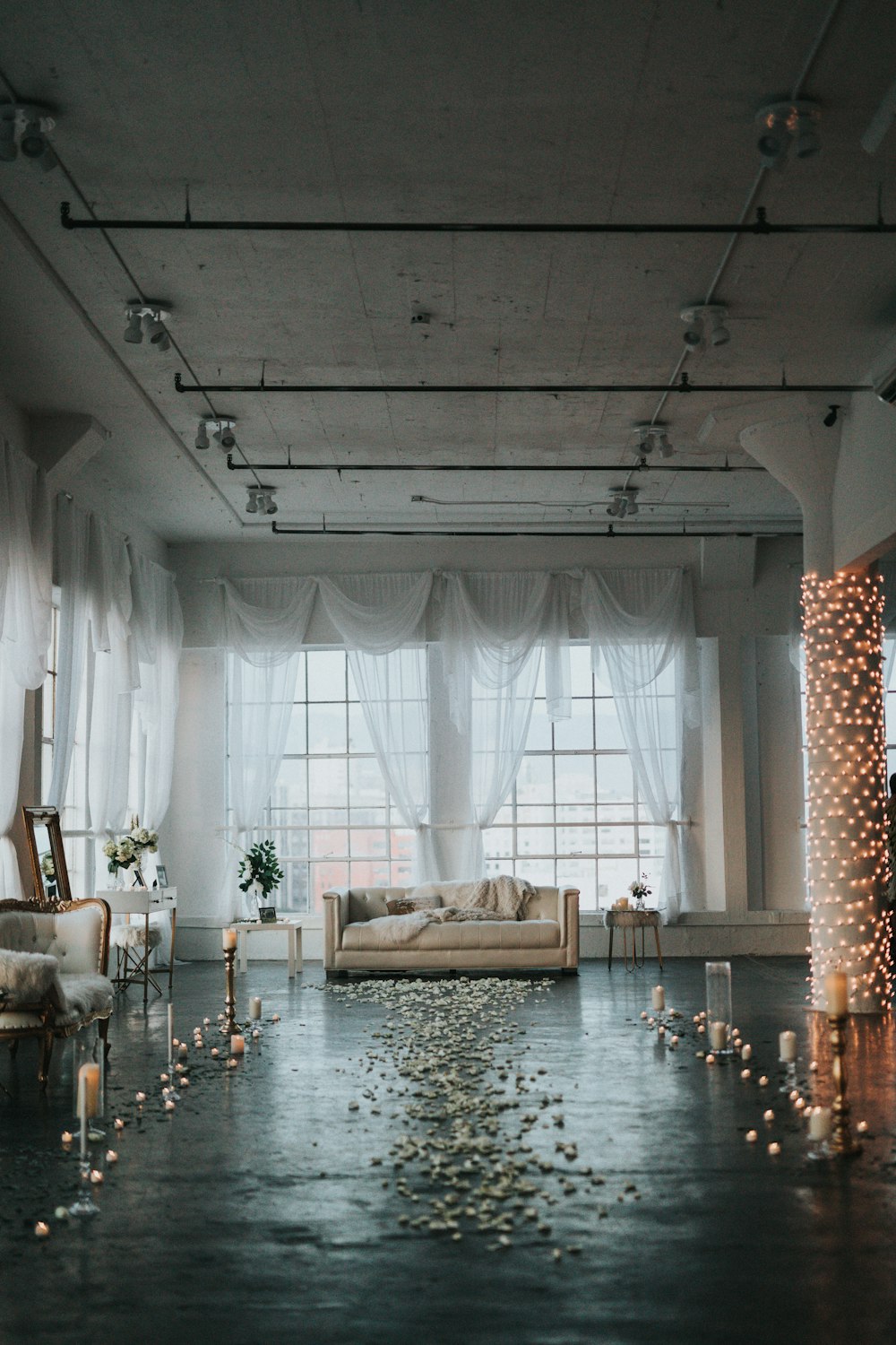 beigefarbenes Sofa in weißem, durchsichtigem Raum mit Vorhängen