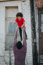 A caregiver and child sharing a joyful moment during a skill-building session outdoors.