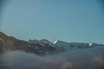 A serene Himalayan landscape with sunlight illuminating high mountain peaks.