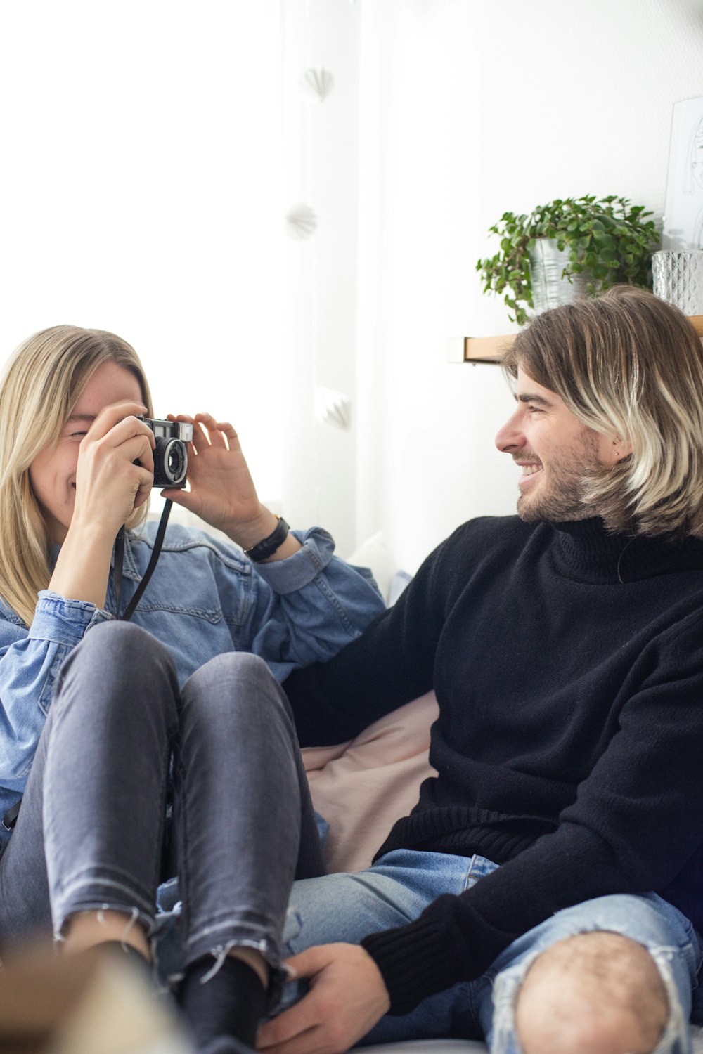 man and woman sitting on pink sofa