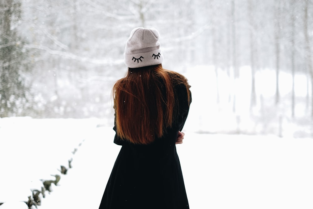 woman standing on white snow-covered field