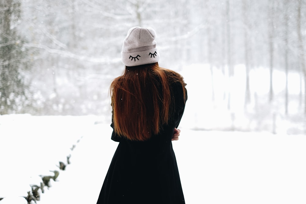 mulher em pé no campo branco coberto de neve