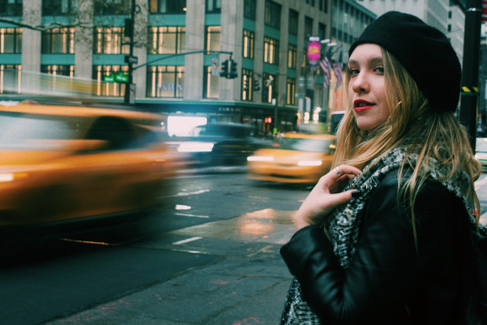 woman wearing black leather jacket standing on street