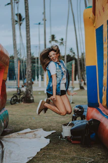 A woman celebrating her fitness milestone with a joyful jump in a park