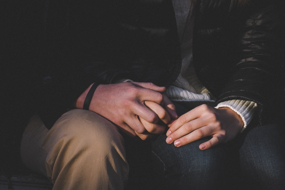 a close up of two people holding hands