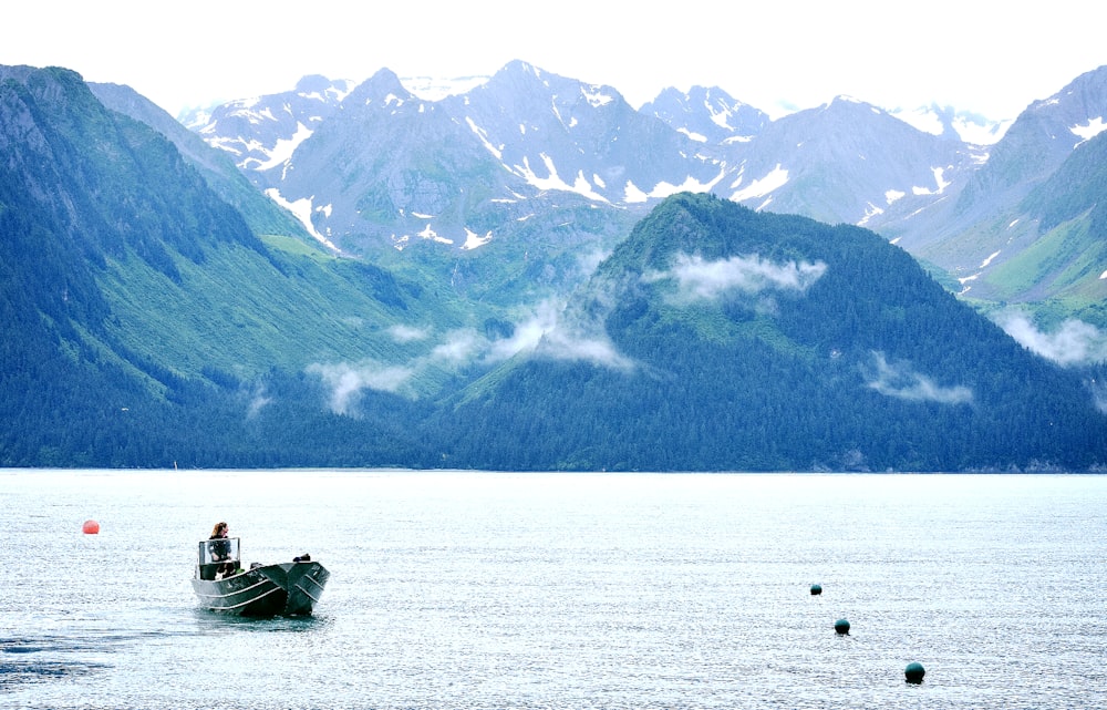 person riding on jon boat during daytime