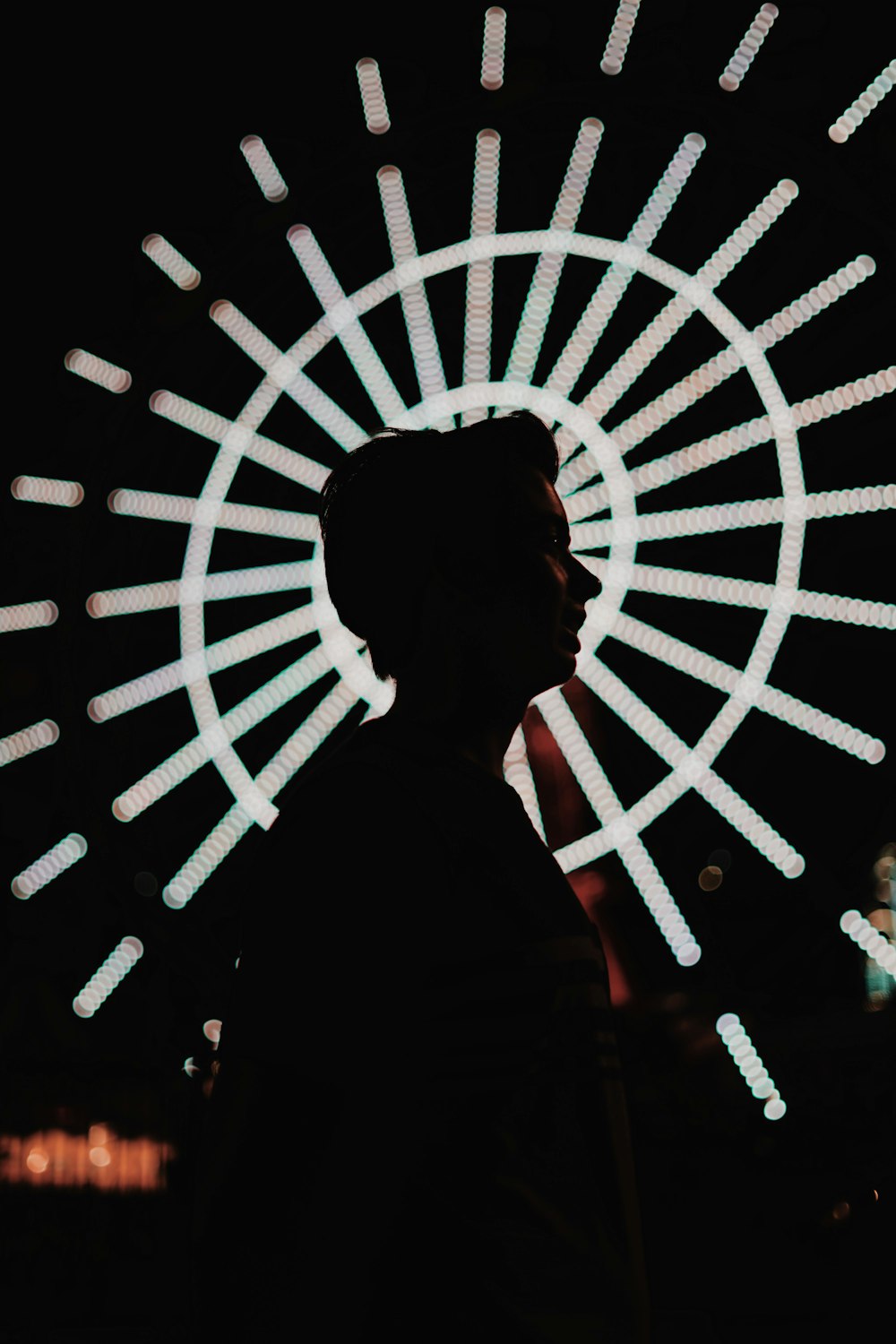silhouette photography of woman standing near lighted ferris wheel