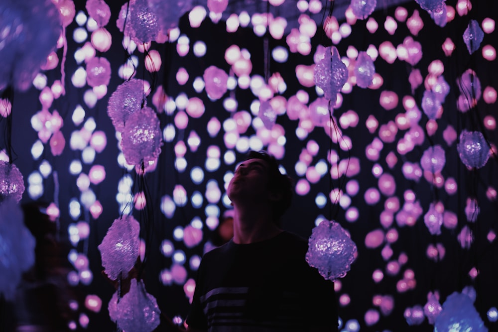 person standing on hanging light with bokeh light background