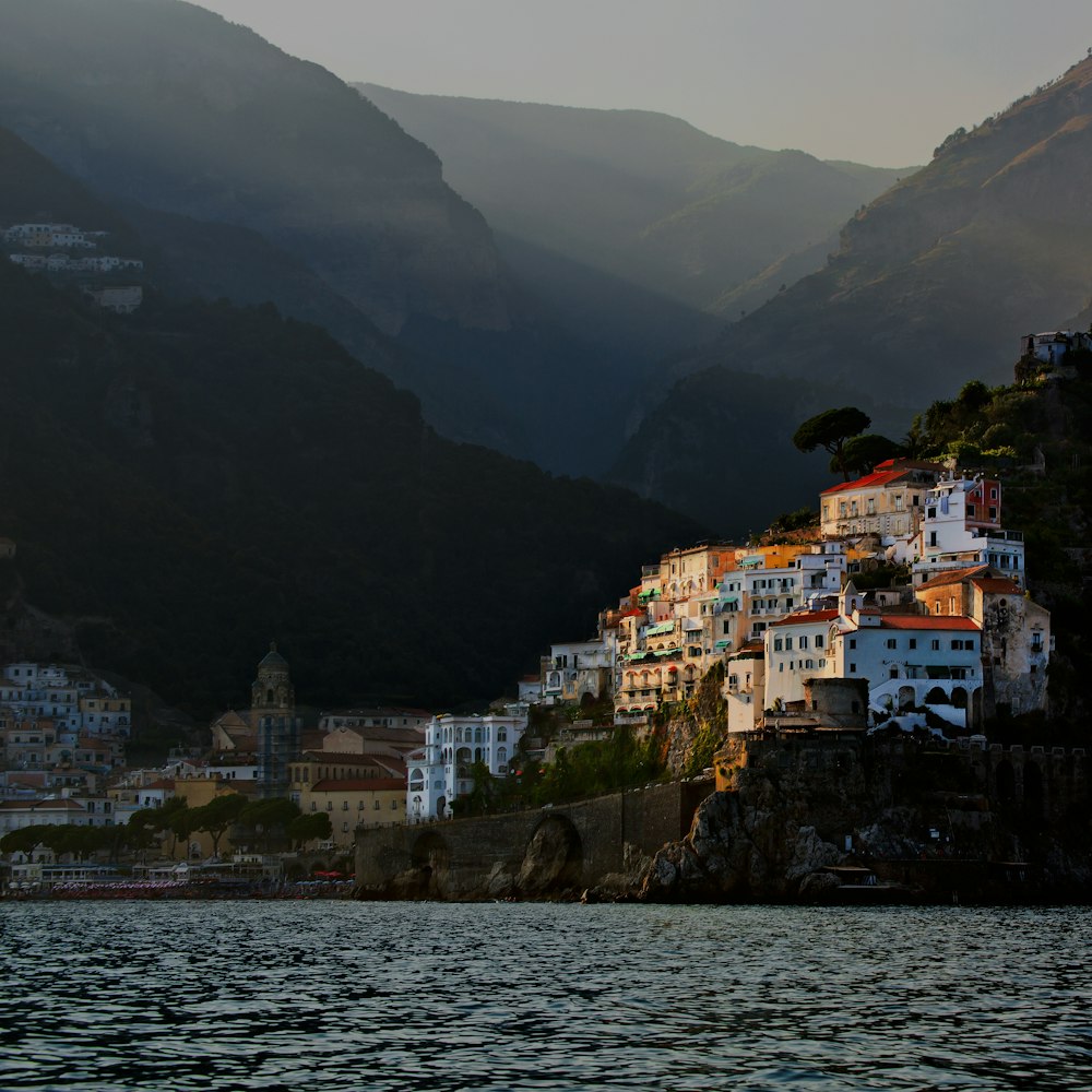 white painted buildings beside body of water