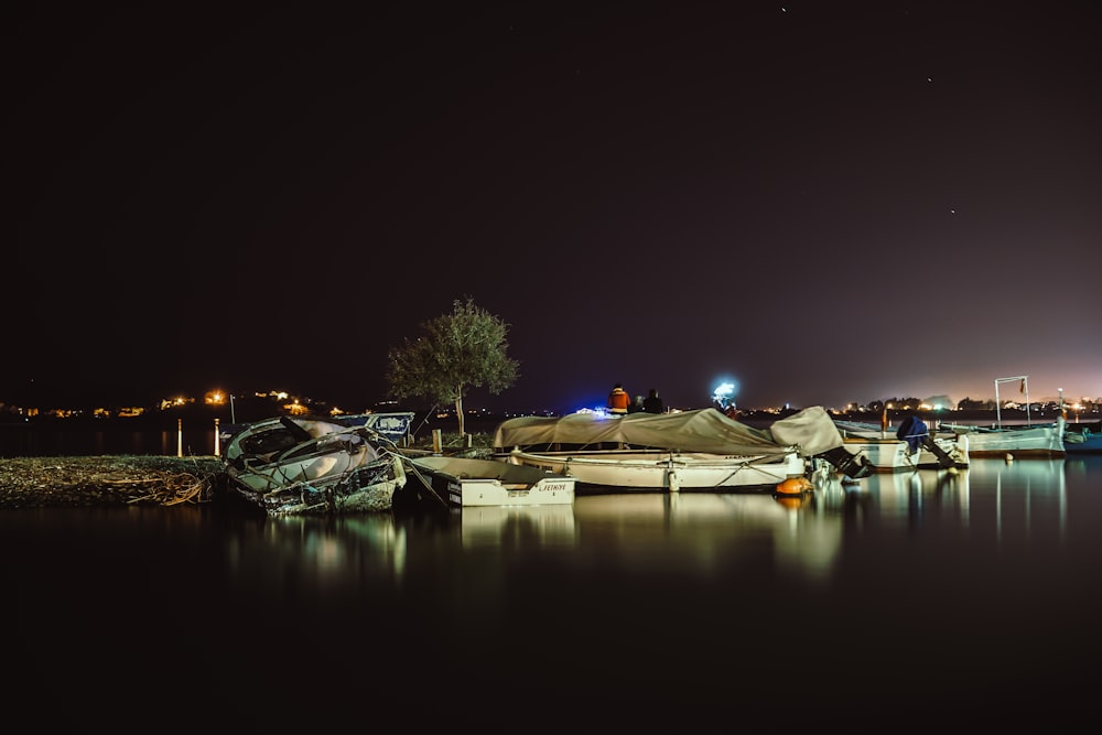 white boats parked on shore during nighttime