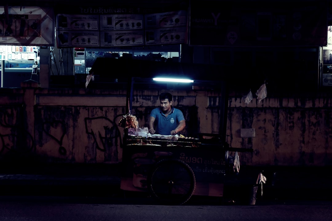 man standing beside food stand,