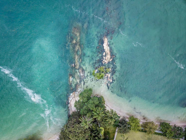 Aerial view of turquoise Caribbean waters and rugged coastline filmed by a professional drone.