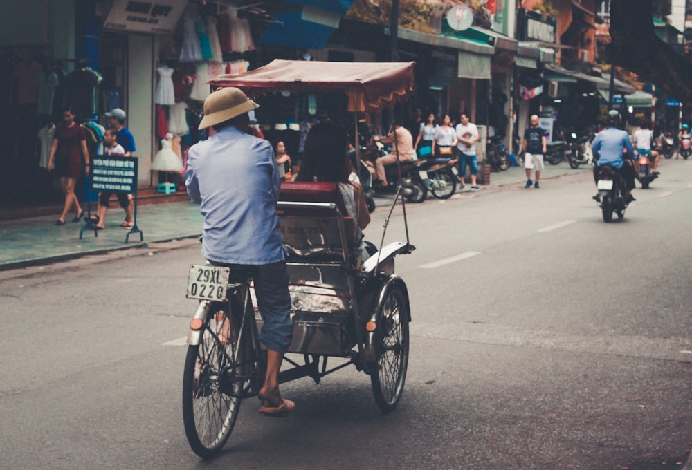 man wearing blue top riding on bicycle