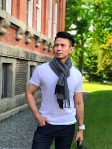 A stylish man wearing a charcoal gray cotton blend scarf outdoors on a crisp autumn day.