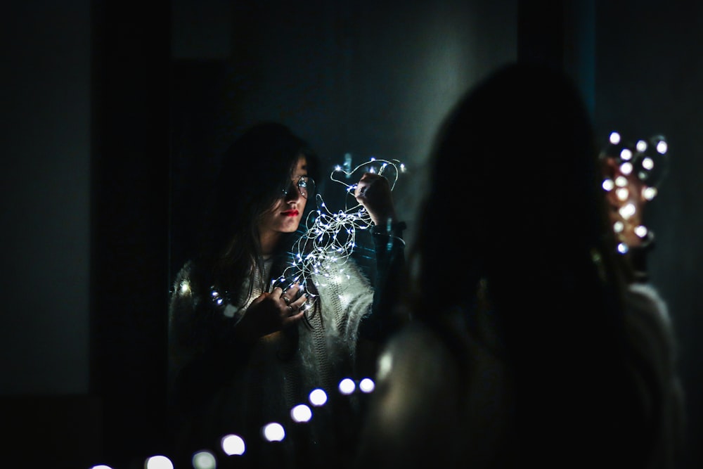 woman holding fairy lights