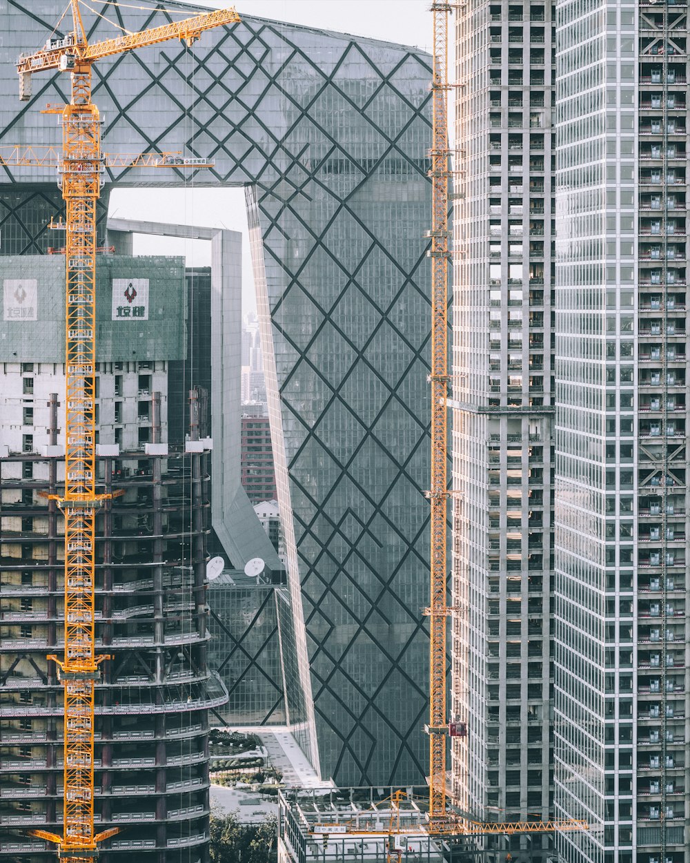 a city with tall buildings and a crane in the foreground