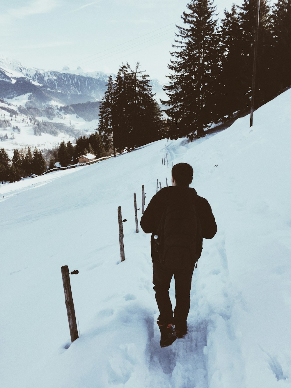 hombre con una mochila caminando sobre la nieve