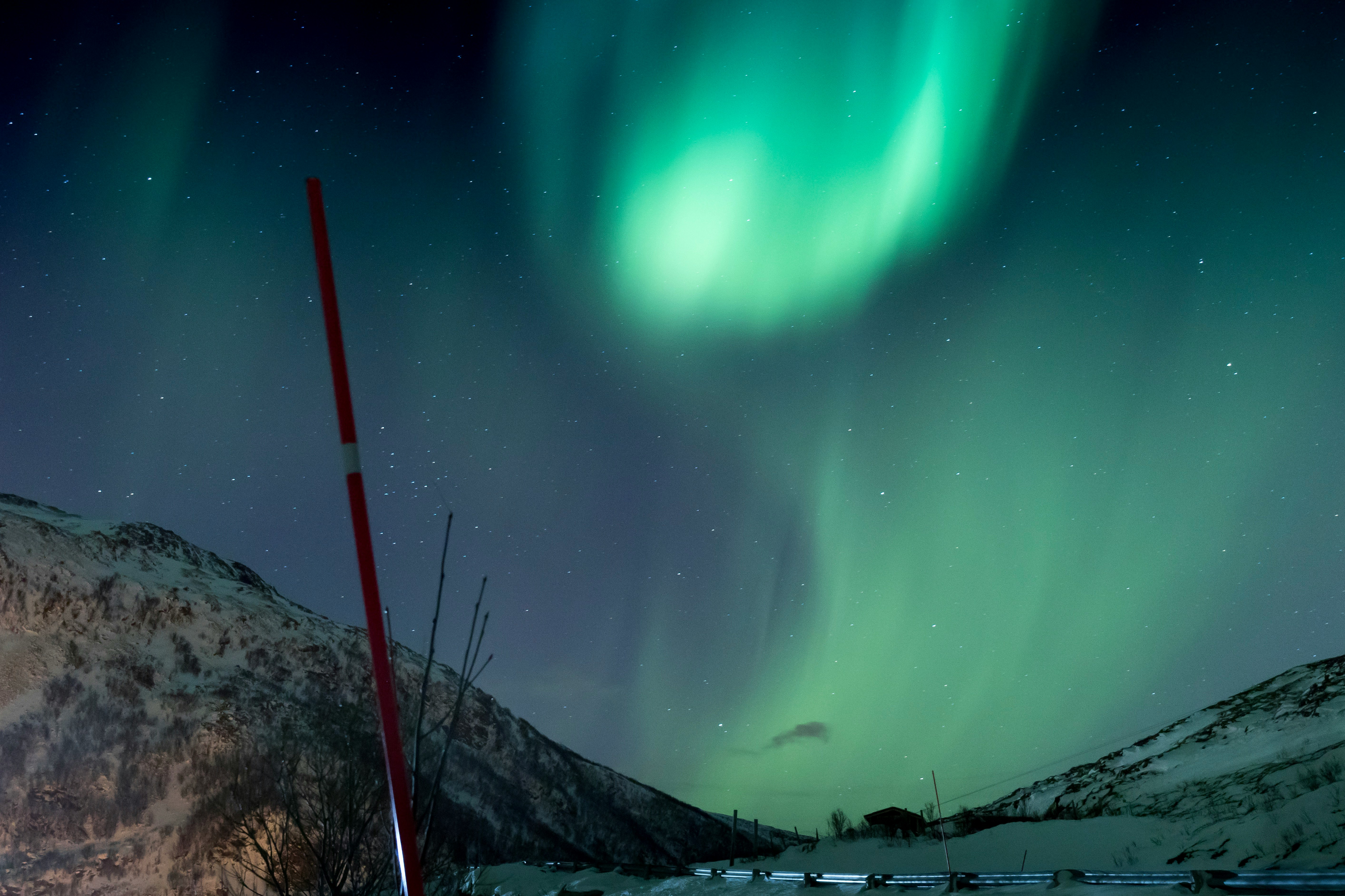 Aurora Borealis about mountain range covered with snow during nighttime
