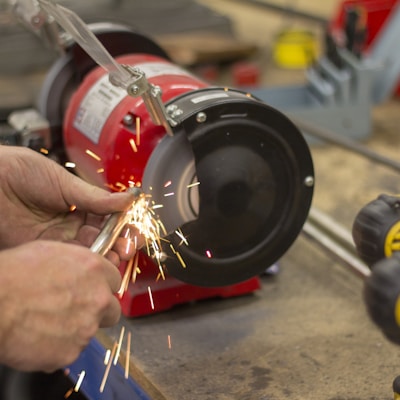 person in front of red bench grinder