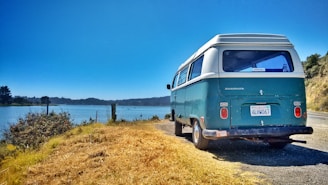 a van parked on the side of a road next to a body of water