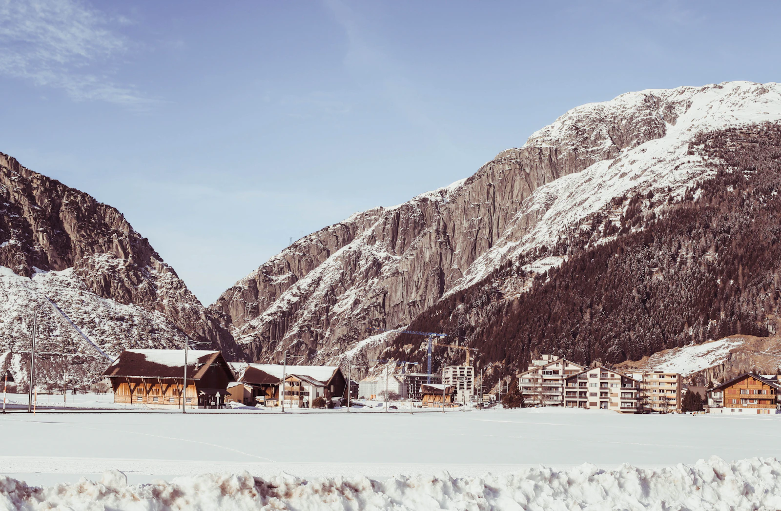 Andermatt houses beneath snow-covered mountains in winter