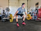 man carrying yellow barbell