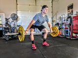 man carrying yellow barbell