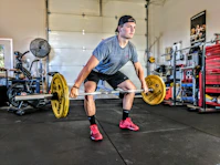 man carrying yellow barbell