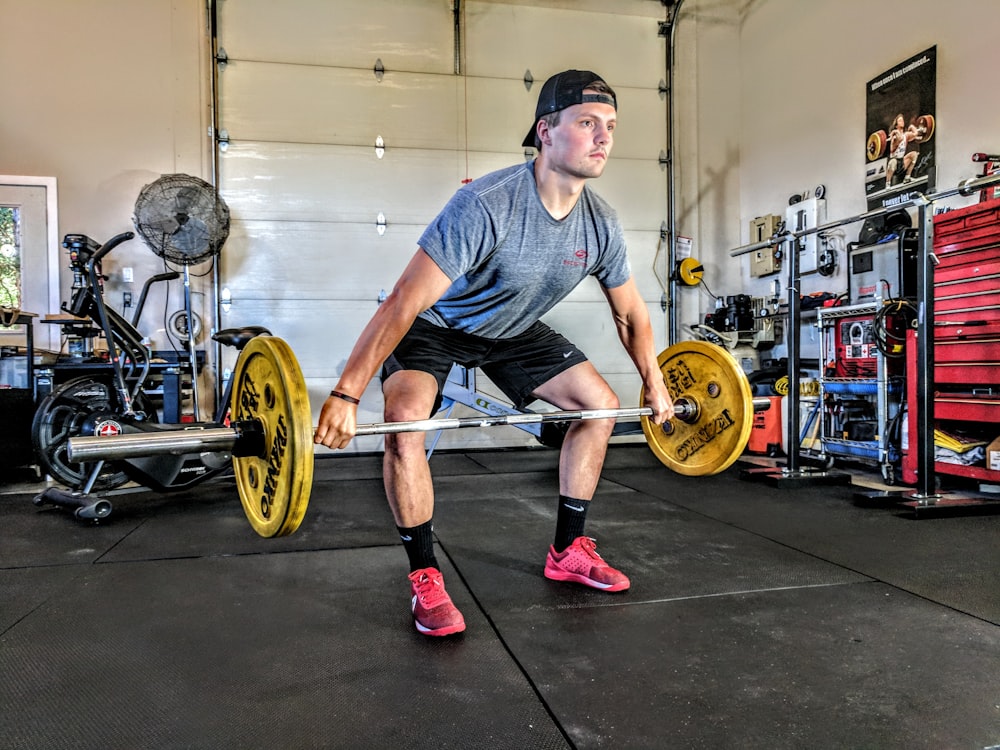 man carrying yellow barbell