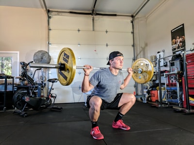 College athlete weightlifting in a garage gym or warehouse.
