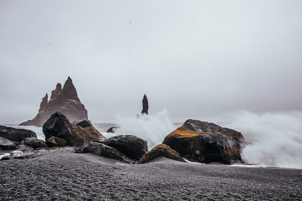 Formação rochosa marrom e cinza perto do corpo de água