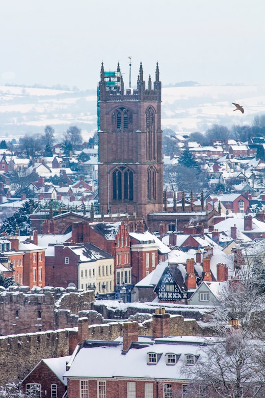 brown tower near houses at daytime in Ludlow United Kingdom