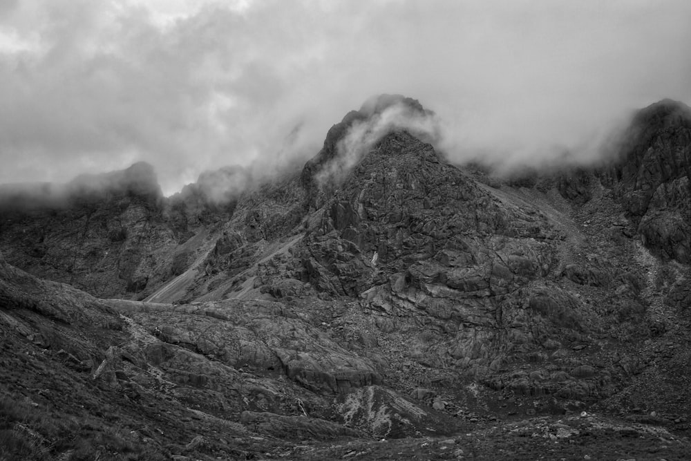 mountain range covered with clouds grayscale photography