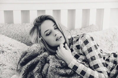 A cozy scene with a model wearing a comfortable cotton lingerie set, surrounded by soft pillows.