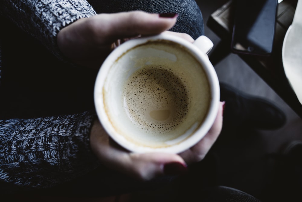 person holding white ceramic mug