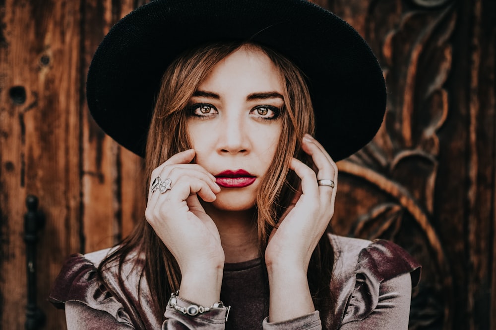 woman wearing sunhat posing near wall