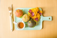 Variety of colorful burger toppings laid out on a wooden board