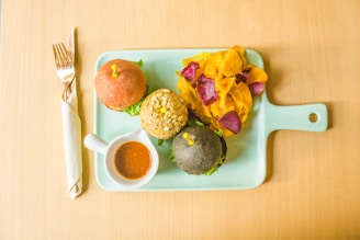 Variety of colorful burger toppings laid out on a wooden board