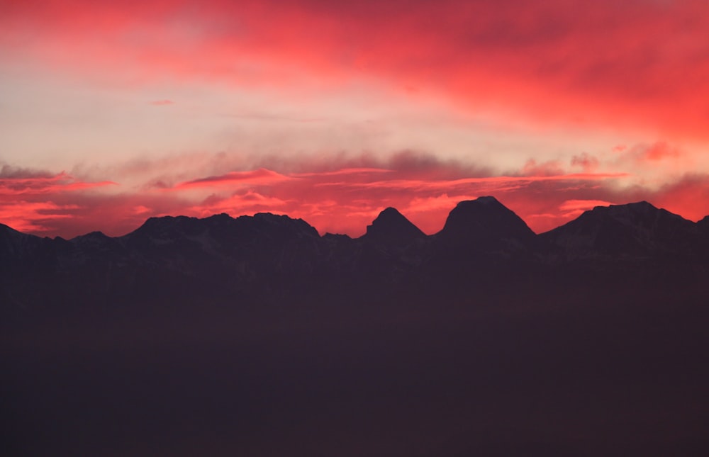silhouette of mountains during red sunset