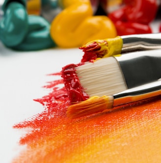 three silver paint brushes on white textile