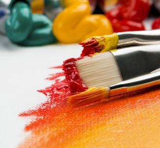 three silver paint brushes on white textile